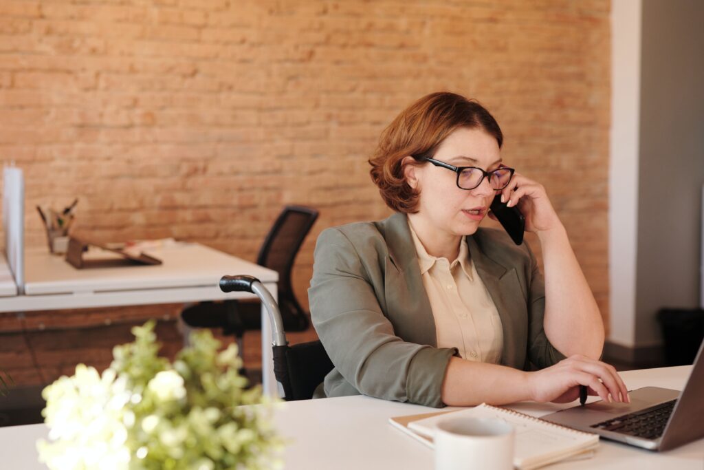 pexels-marcus-aurelius-4064227 Lady on phone in front of laptop